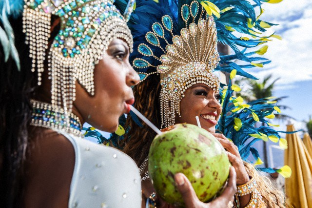 Samba dancers in costume, drinking coconut drinks, Ipanema Beach, Rio De Janeiro, Brazil