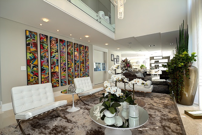 Para compor a sala de estar foram escolhidos tons neutros e móveis confortáveis, com design  clássico; a obra de arte na parede ganha destaque com as cores vivas. (Foto: Gilmar Veng)
